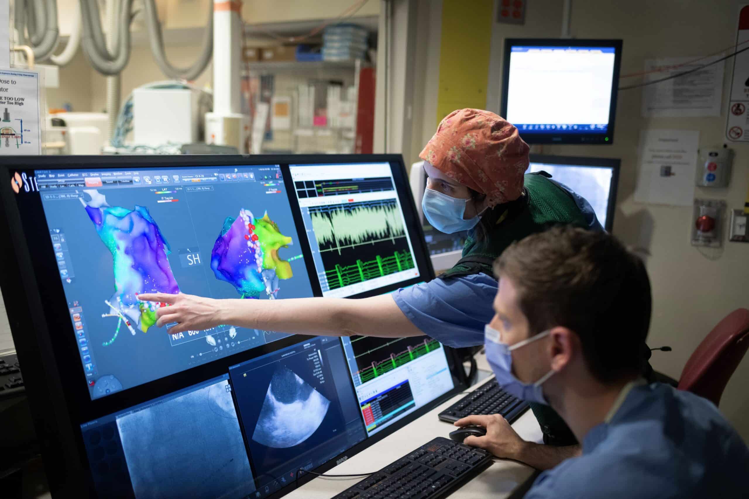 Two physicians looking at a heart scan image on the computer
